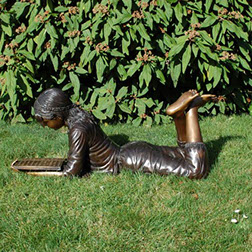 Bronzefigur Paula "Liegendes Mädchen mit Buch". Bronzefiguren und Gartenfiguren bei Kunsthandel Lohmann in Timmendorfer Strand.